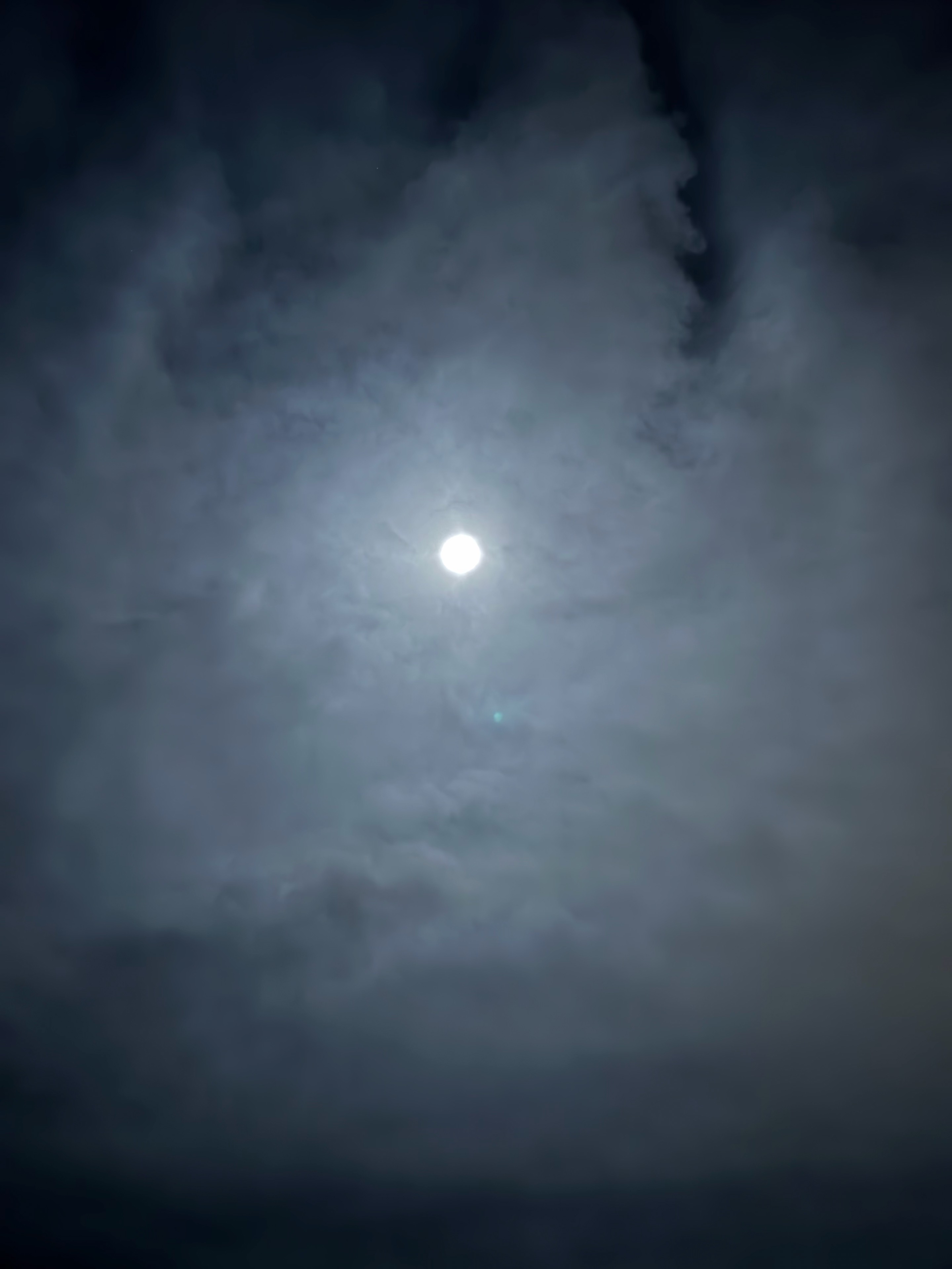 JC’s photograph of the moon glowing through textured clouds.